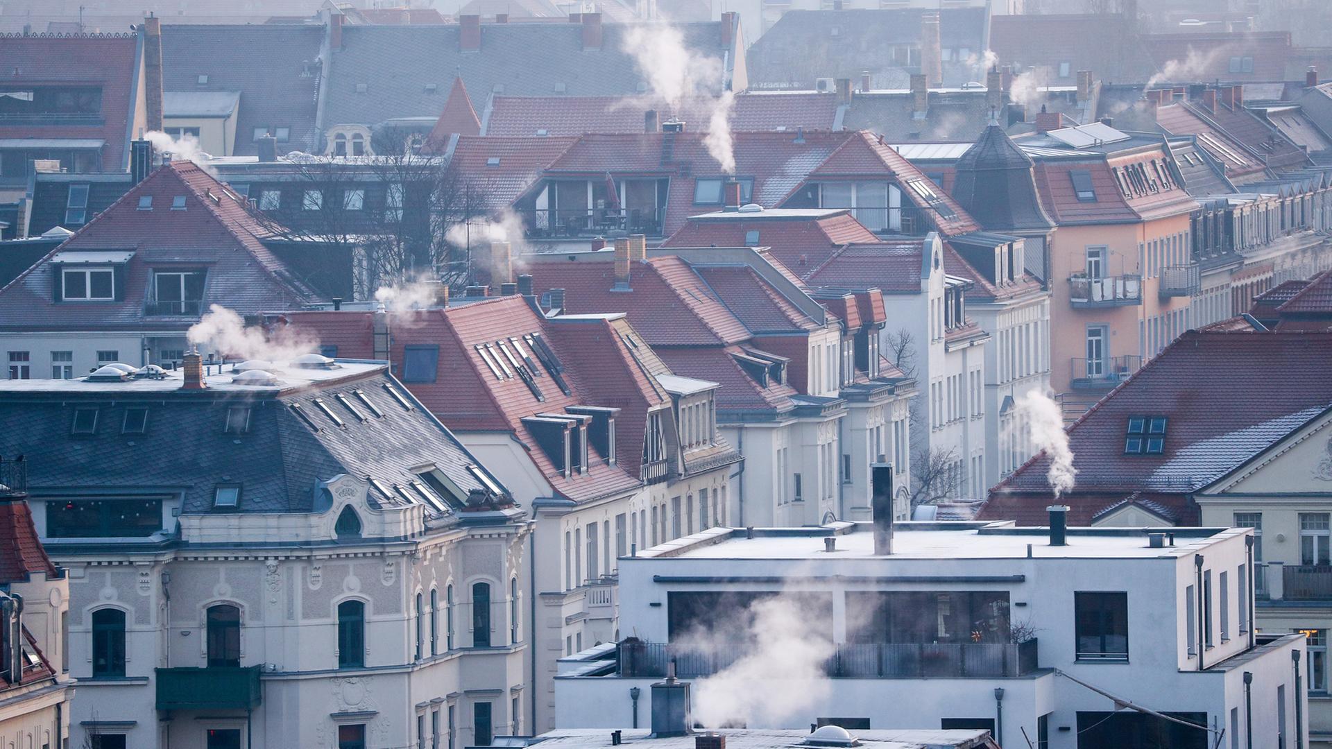 Rauch strÃ¶mt aus den Kaminen auf den DÃ¤chern der MehrfamilienhÃ¤user im Leipziger SÃ¼den an einem kalten Wintermorgen. | picture alliance/dpa/dpa-Zentral