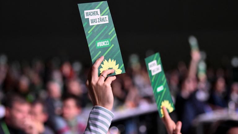 Delegierte der Grünen halten beim Bundesparteitag Stimmkarten in die Höhe