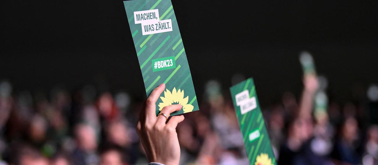 Delegierte der Grünen halten beim Bundesparteitag Stimmkarten in die Höhe