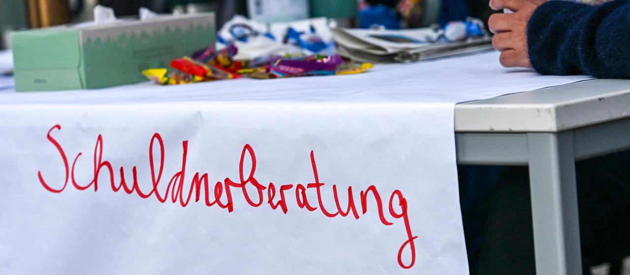 Ein Hinweisschild „Schuldnerberatung“ bei einer Jobmesse im Jobcenter. 
