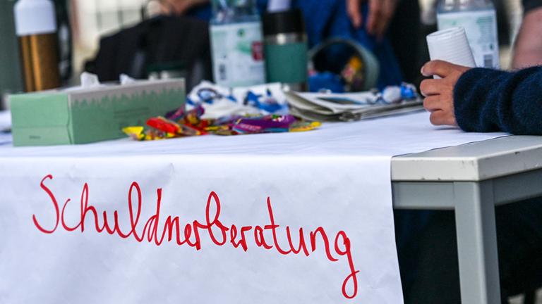 Ein Hinweisschild „Schuldnerberatung“ bei einer Jobmesse im Jobcenter. 