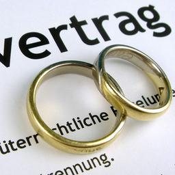 Ringe liegen auf einem Ehevertrag.