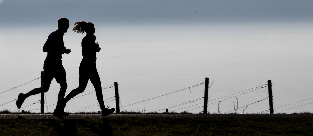 Ein Mann und eine Frau joggen nebeneinander | dpa Ein Mann und eine Frau joggen nebeneinander