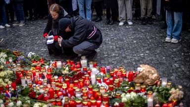 Nach dem Schusswaffenangriff in Prag legen Menschen Blumen und Kerzen vor dem Gebäude der Karls-Universität nieder