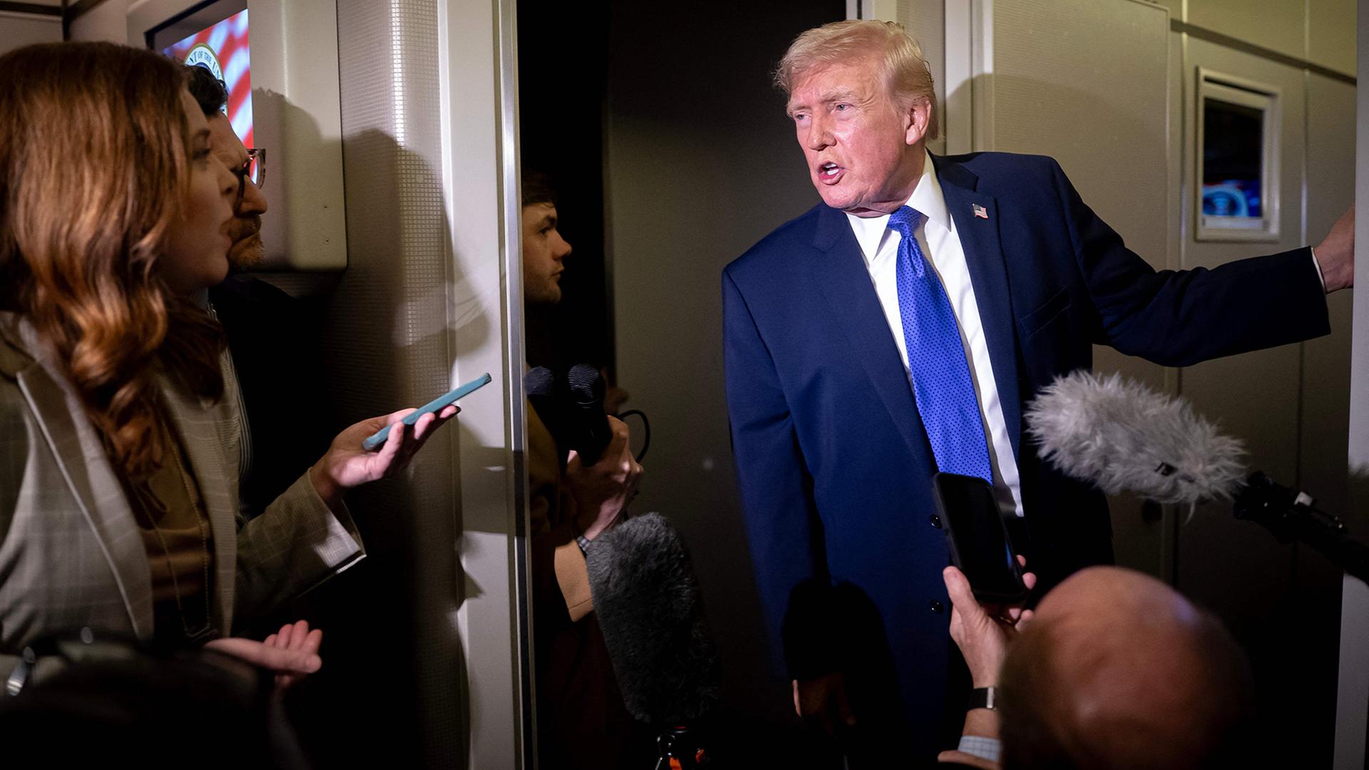 Donald Trump spricht in der Air Force One zu Journalisten. | Getty Images via AFP