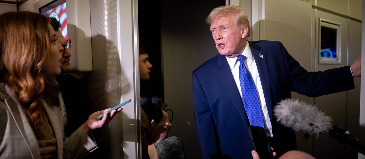Donald Trump spricht in der Air Force One zu Journalisten.