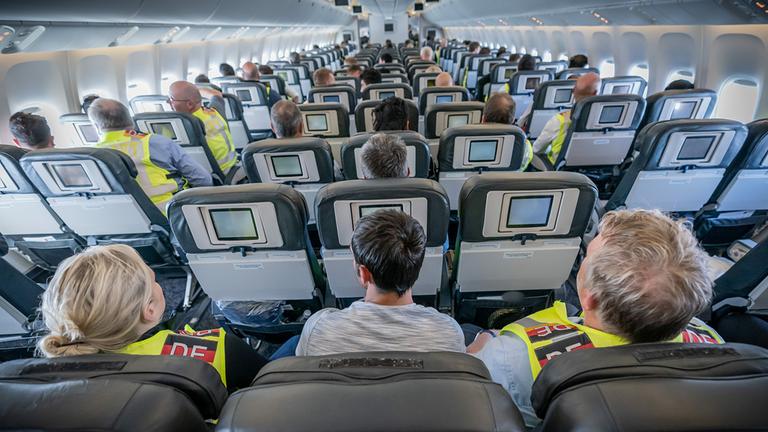 Zwei Polizeibeamte eskortieren einen Afghanen auf dem Flug von Leipzig nach Kabul in einem Charterflugzeug.