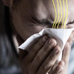 Eine Person niest in ein Taschentuch.