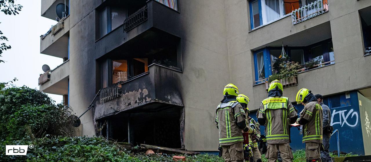 13.10.2025, Berlin: Einsatzkräfte der Feuerwehr stehen vor einer ausgebrannten Wohnung in Berlin-Neukölln.(Quelle:dpa/F.Sommer)