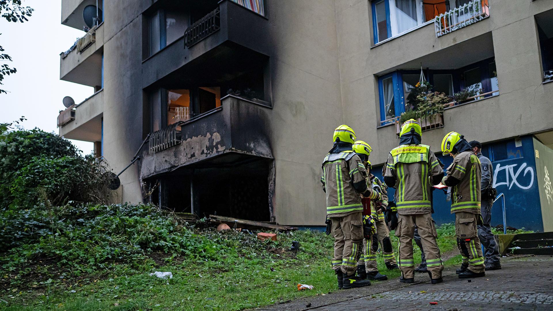 13.10.2025, Berlin: Einsatzkräfte der Feuerwehr stehen vor einer ausgebrannten Wohnung in Berlin-Neukölln.(Quelle:dpa/F.Sommer) | dpa/F.Sommer