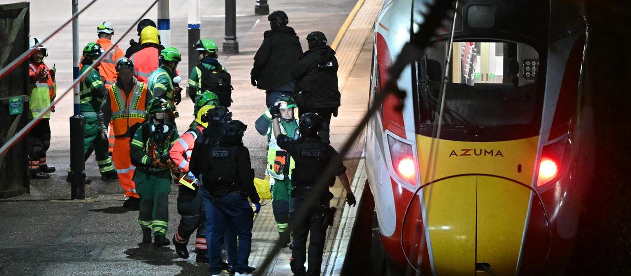 Polizisten und Rettungskräfte stehen neben einem Zug am Bahnhof | AFP Polizisten und Rettungskräfte stehen neben einem Zug am Bahnhof