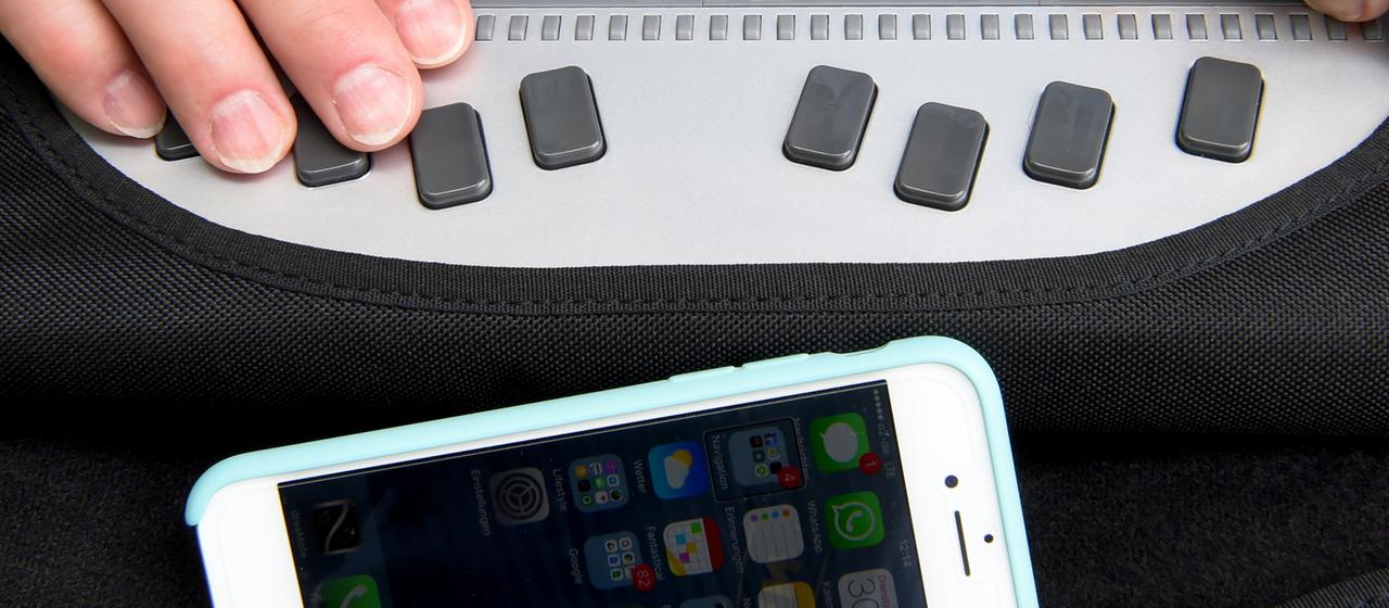 Ein Smartphone ist mit einer Braille-Tastatur für Blinde verbunden.
