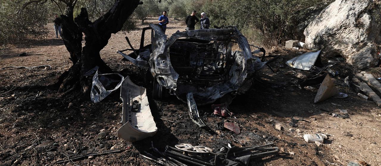 Palästinenser betrachten die Trümmer eines Fahrzeugs im Dorf Kfar Kud.