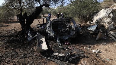 Palästinenser betrachten die Trümmer eines Fahrzeugs im Dorf Kfar Kud.