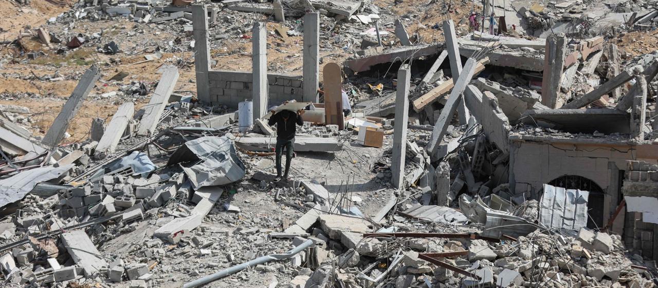 Menschen durchsuchen zerstörte Gebäude und Trümmer im Gazastreifen