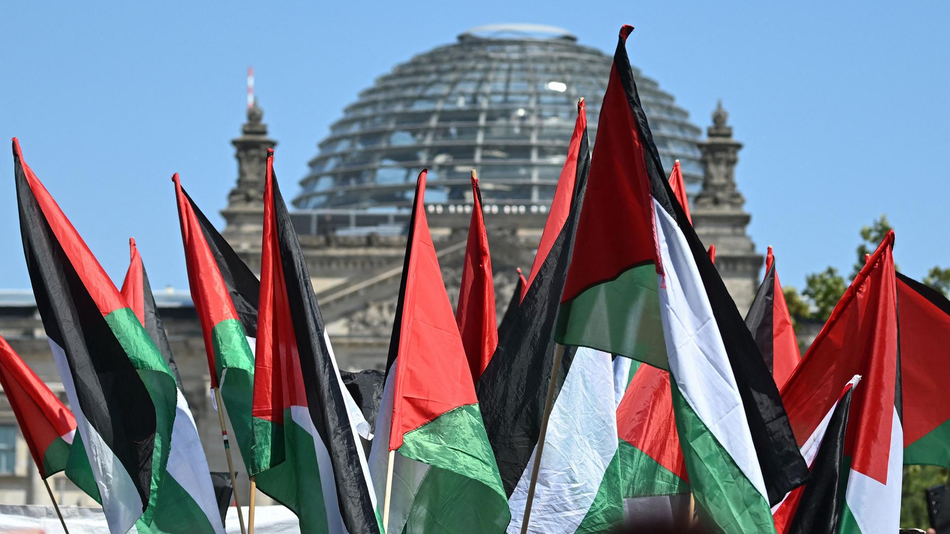 Palästinensische Flaggen wehen vor dem Reichstagsgebäude in Berlin. | AFP