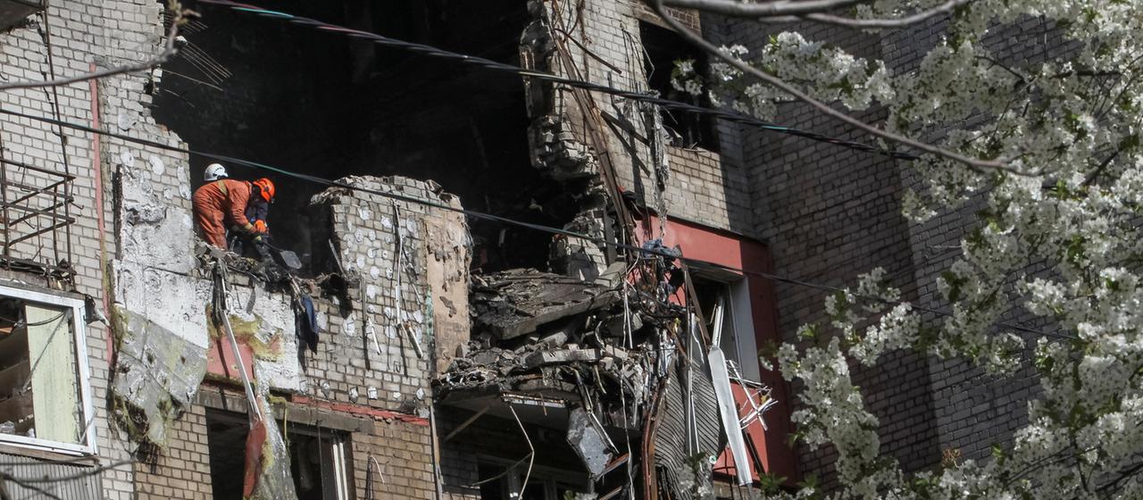 Rettungskräfte arbeiten an einem von Angriffen beschädigten Gebäude in Dnipro