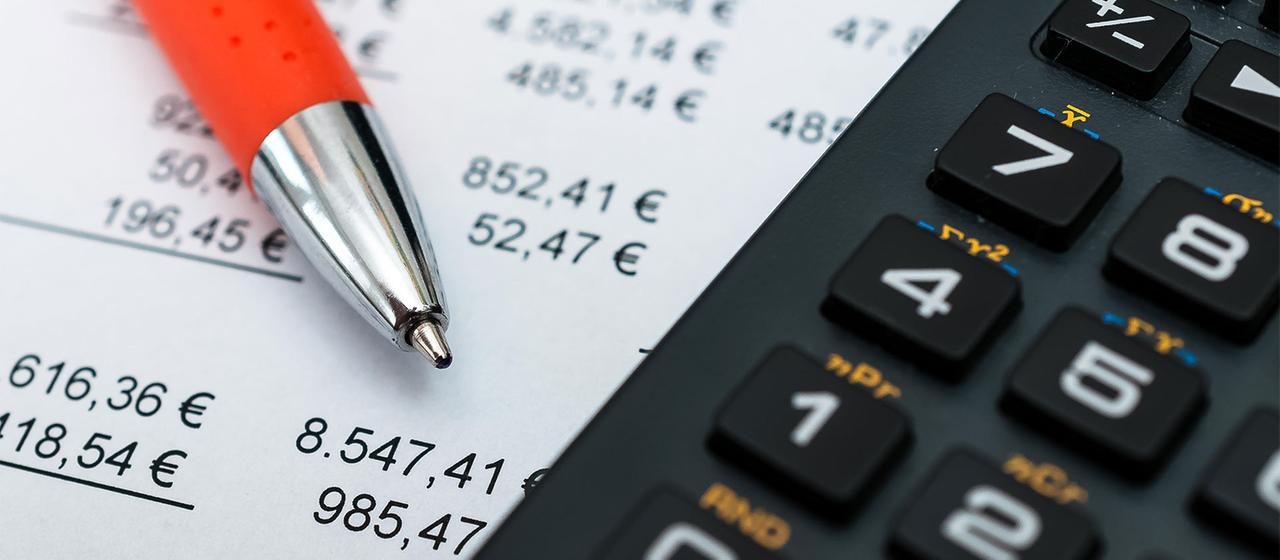 Rendite-Umsatzstatistik, ein roter Kugelschreiber und ein Taschenrechner.