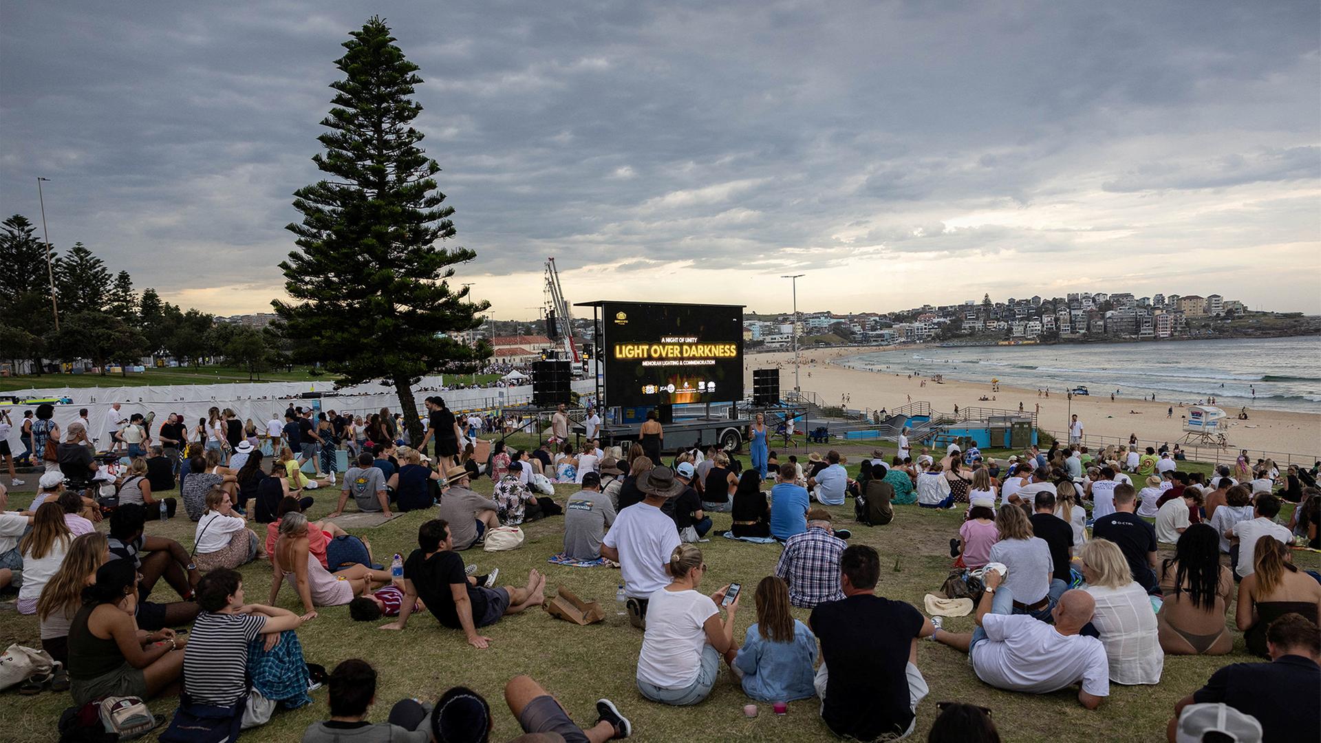 Menschen sitzen bei der Gedenkfeier 