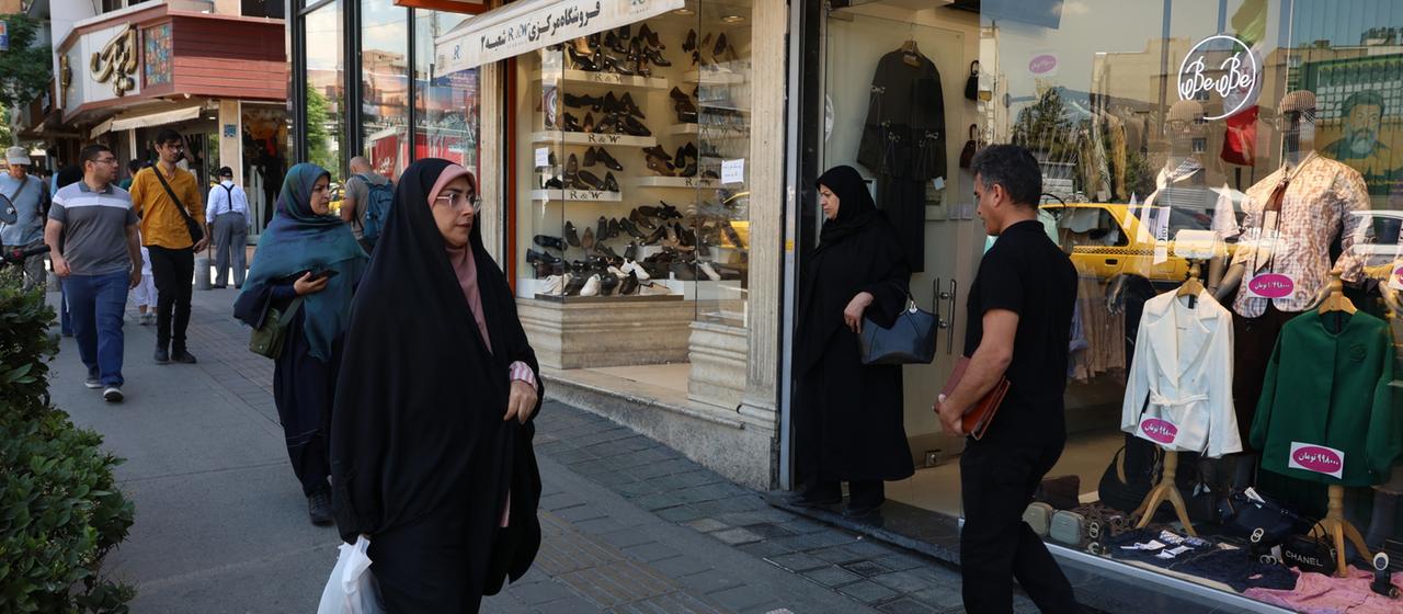 Menschen gehen an Geschäften im iranischen Teheran vorbei.