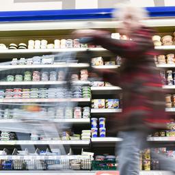 Eine Kundin geht im Supermarkt an einem Kühlregal vorbei.