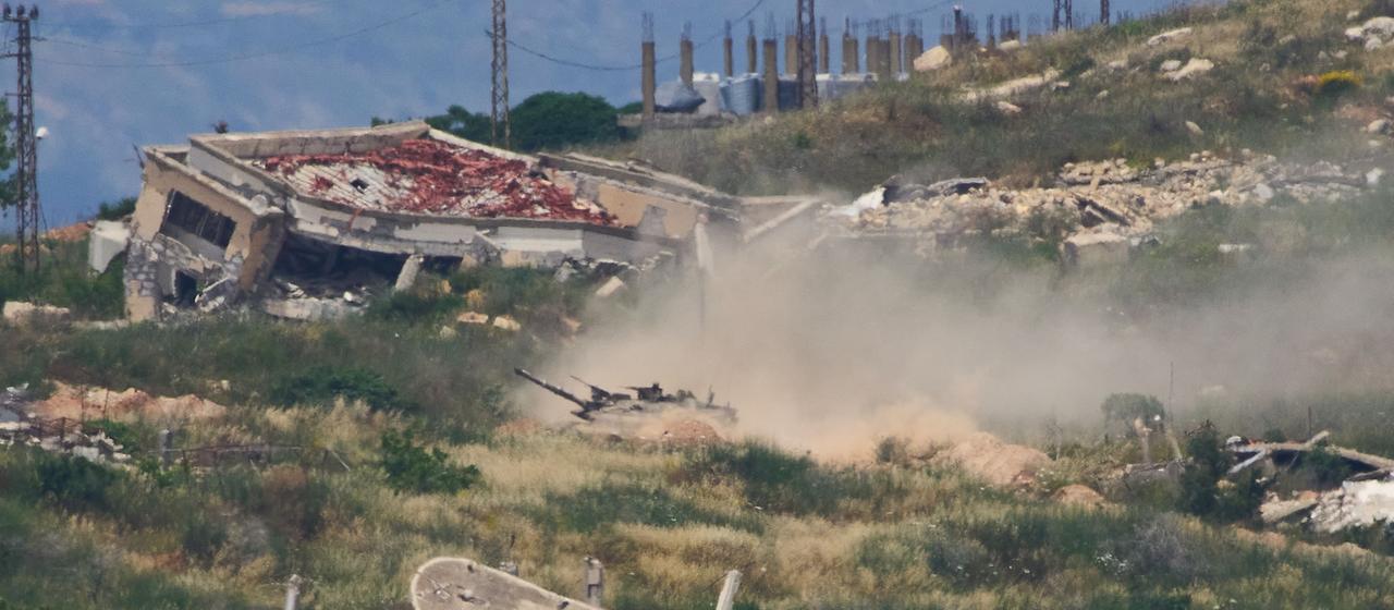 Von Nordisrael aus gesehen fahren israelische Soldaten mit einem Panzer durch den Südlibanon.