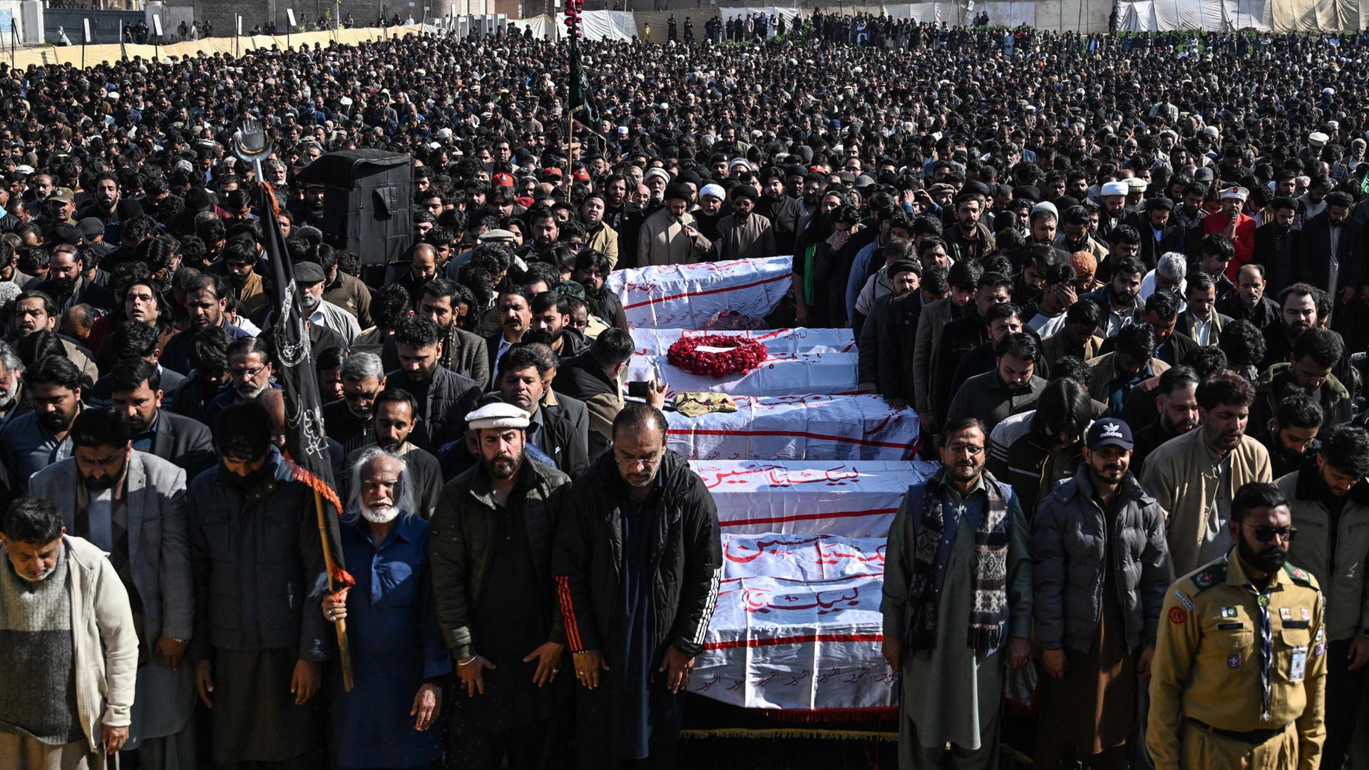 Tausende Trauernde stehen um S�rge in Islamabad. | AFP