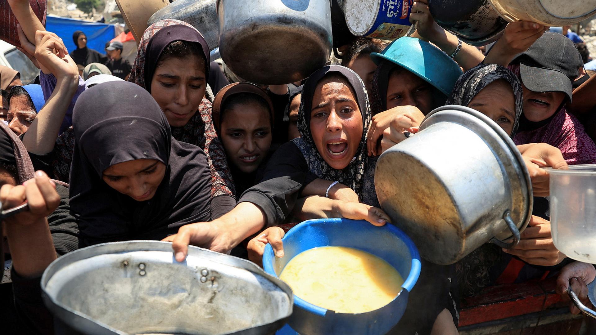 Palästinenser warten an einer Suppenküche in Gaza-Stadt auf Essen. | REUTERS