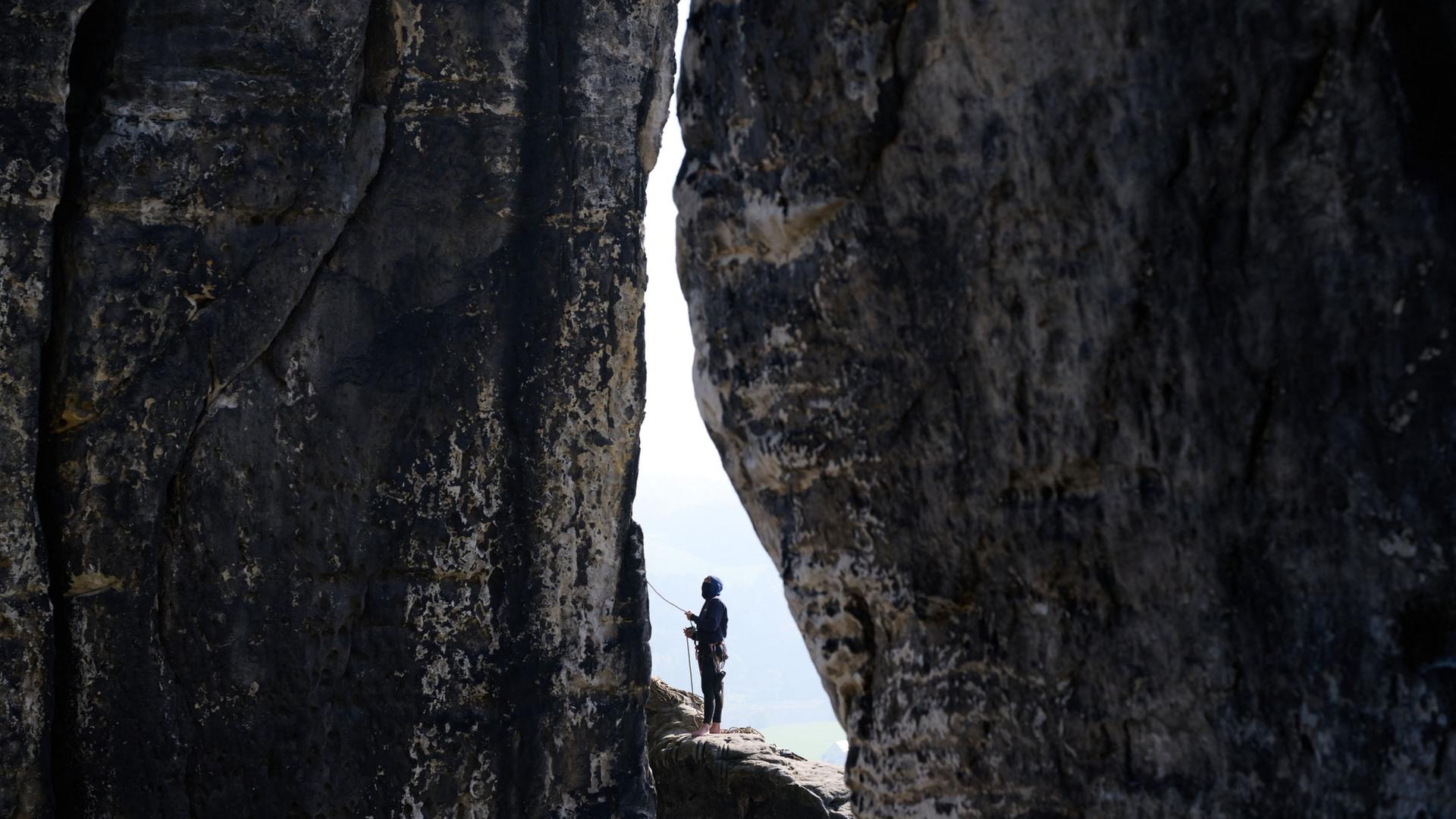 Ein Kletterer sichert eine andere Person beim Klettern am Felsen an der BasteibrÃ¼cke in der SÃ¤chsischen Schweiz. | Katharina Kausche/dpa