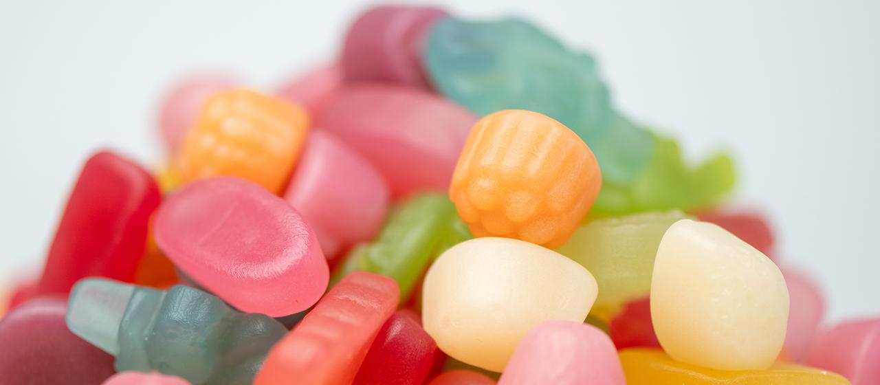 Verschiedene Fruchtgummis in bunten Farben liegen übereinander.