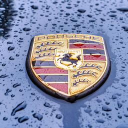 Porsche Emblem auf einer Motorhaube im Regen