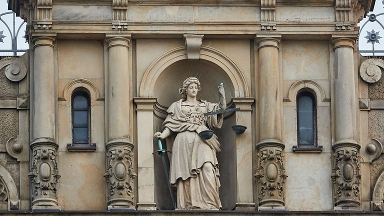 Eine Skulptur der Justitia, der römischen Göttin der Gerechtigkeit, steht über dem Haupteingang des Hamburger Strafjustizgebäudes. 