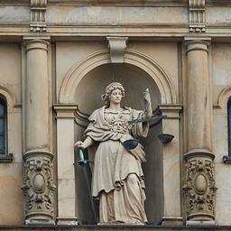 Eine Skulptur der Justitia, der römischen Göttin der Gerechtigkeit, steht über dem Haupteingang des Hamburger Strafjustizgebäudes. 
