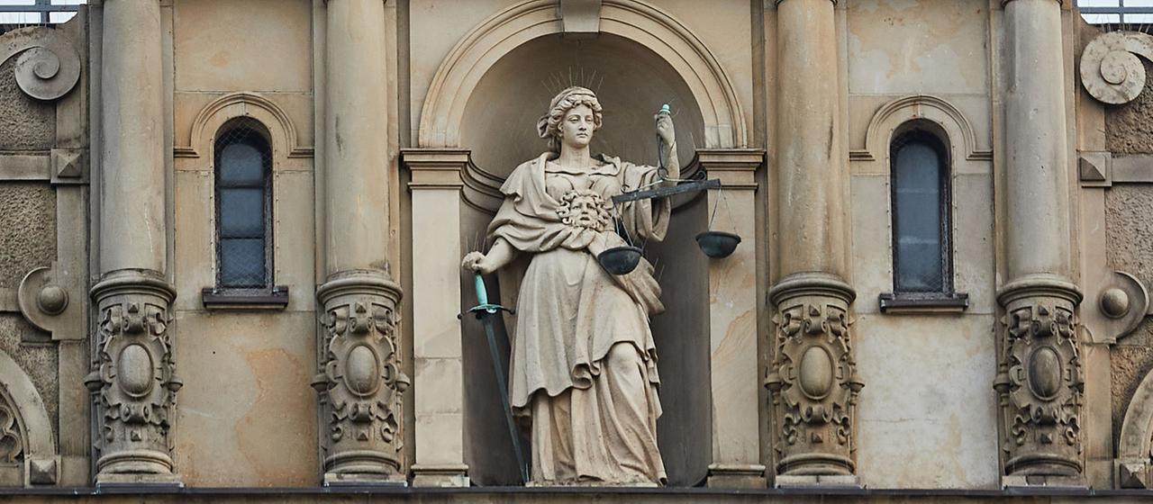 Eine Skulptur der Justitia, der römischen Göttin der Gerechtigkeit, steht über dem Haupteingang des Hamburger Strafjustizgebäudes. 