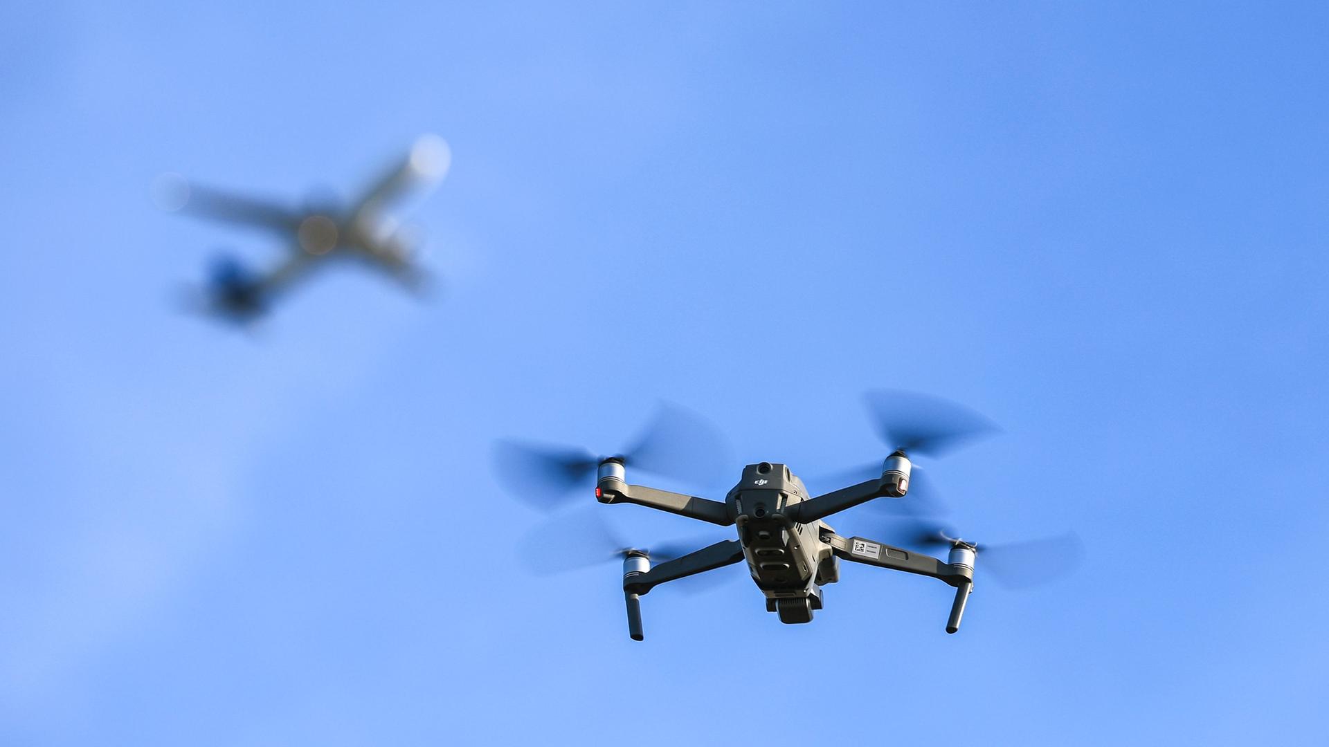 Eine Drohne fliegt vor einem startenden Flugzeug in der Nähe des Flughafens Leipzig/Halle. | Foto: Jan Woitas/dpa