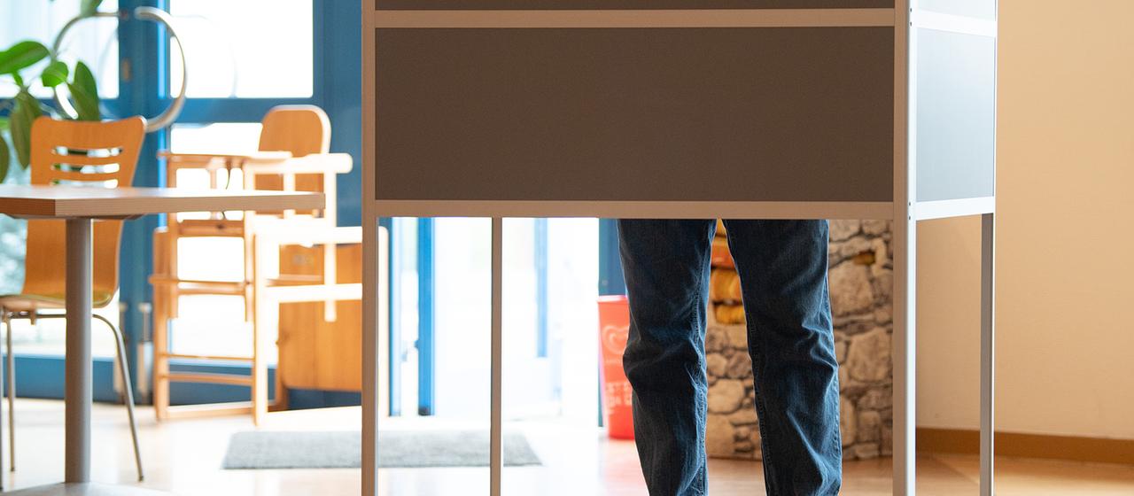 Ein Wähler steht bei der Stimmabgabe in Magdeburg in einem Wahllokal in einer Wahlkabine.