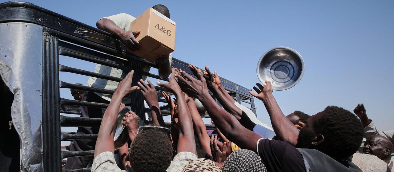 Helfer verteilen von einem LKW im Sudan Lebensmittel.