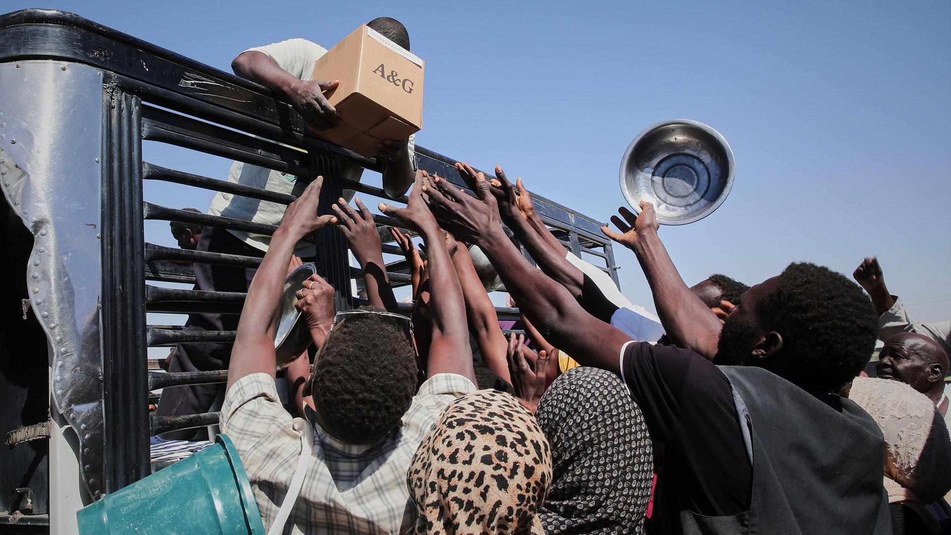 Helfer verteilen von einem LKW im Sudan Lebensmittel. | AP