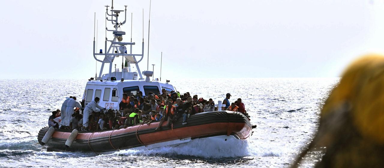 Migranten auf einem Boot vor Italien