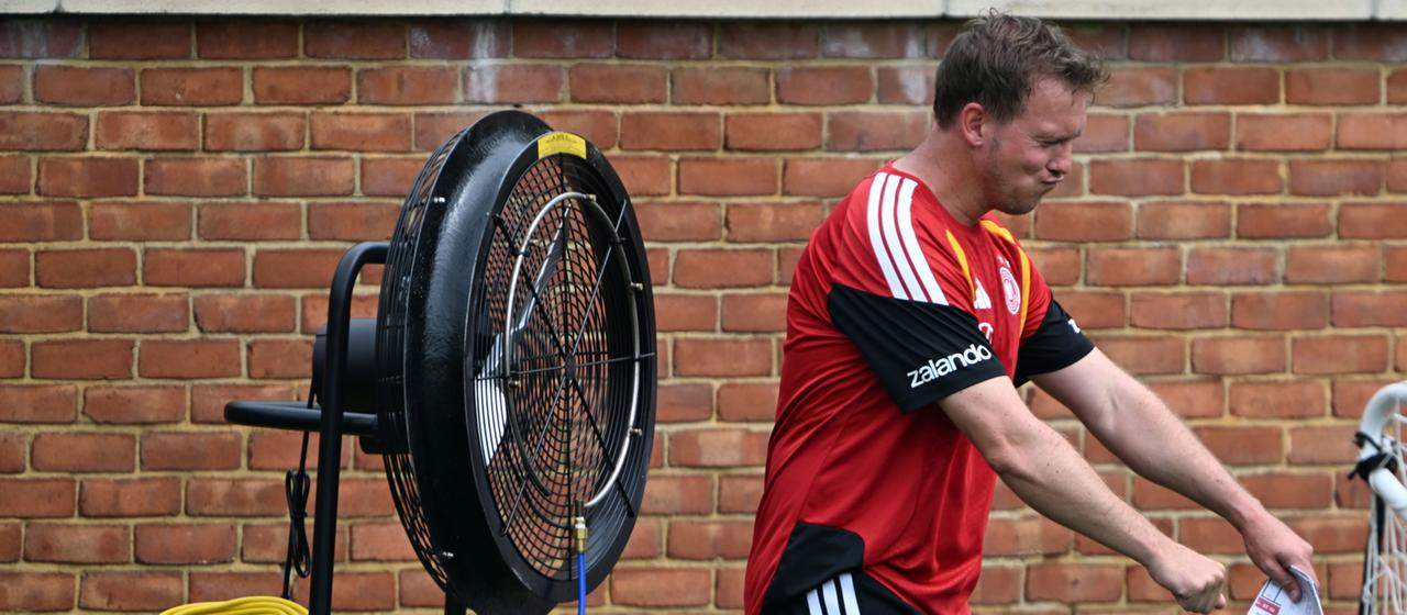 Julian Nagelsmann erfrischt sich vor einem Ventilator.