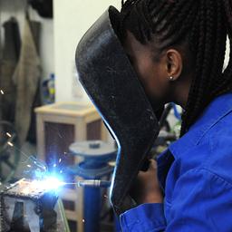 Eine Frau aus Guinea absolviert in der Metallwerkstatt der Allgemeinen Berufsschule in Bremen einen Kurs im E-Schweißen.