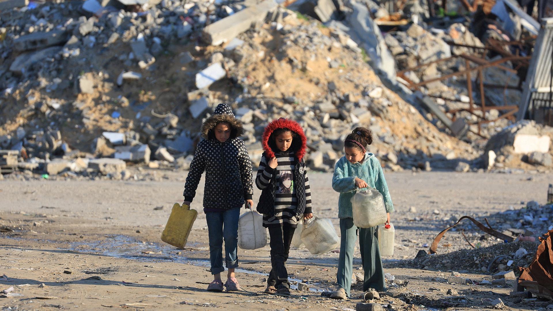 Drei Kinder holen Wasser zwischen Trümmern in Gaza-Stadt. | REUTERS
