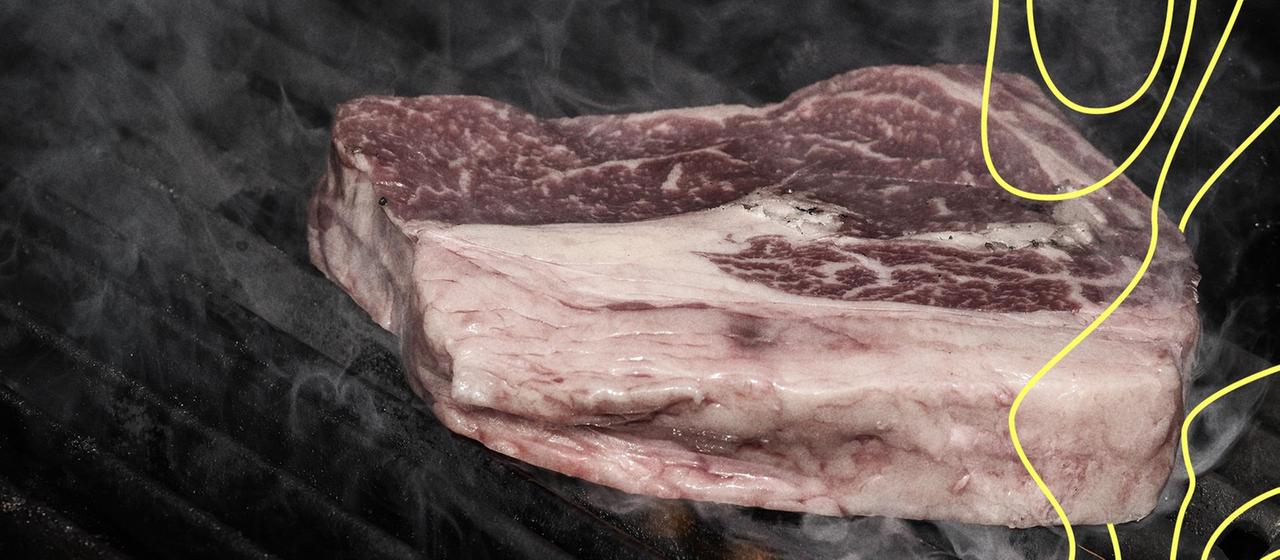 Ein Ribeye-Rindersteak auf offenem Außengrill.