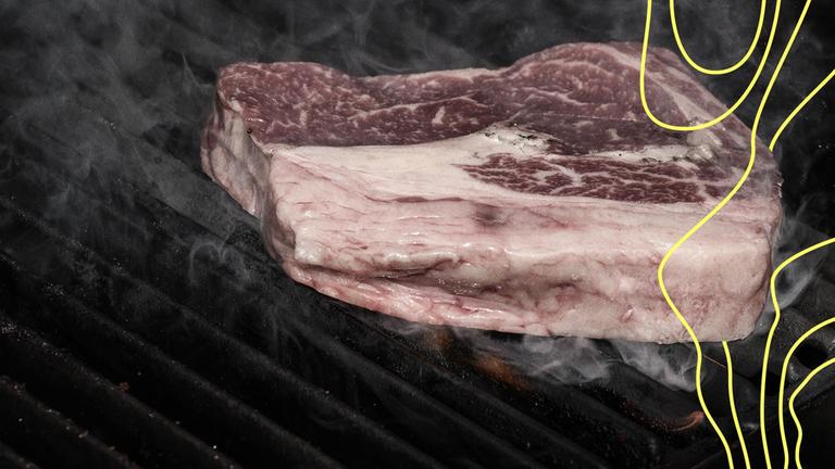 Ein Ribeye-Rindersteak auf offenem Außengrill.