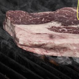 Ein Ribeye-Rindersteak auf offenem Außengrill.