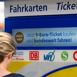 Eine junge Frau steht am Hauptbahnhof an einem Fahrkartenautomaten, auf dem Werbung für das 9-Euro-Ticket zu sehen ist.