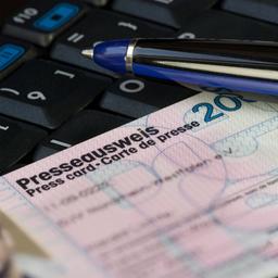 Ein Presseausweis liegt auf einer Tastatur.
