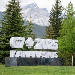 Ein Fotograf vor einem Schild zum G7-Gipfel in Kananaskis
