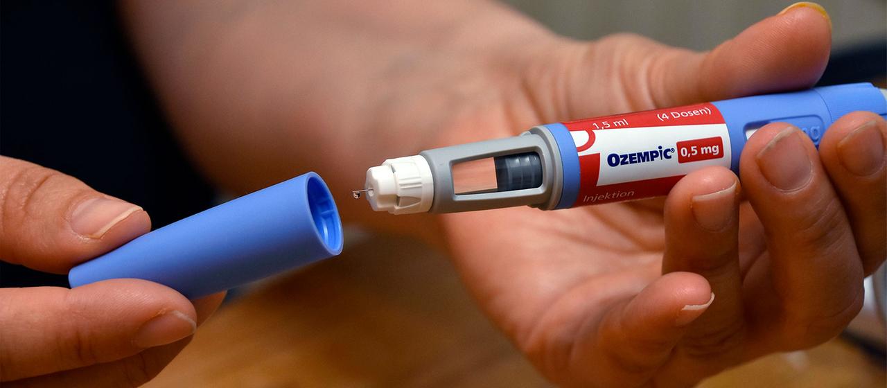 Eine Person hält eine Ozempic Spritze in der Hand.