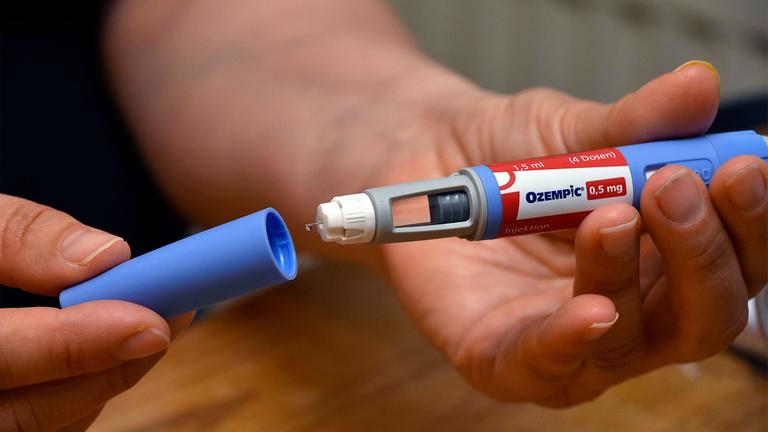 Eine Person hält eine Ozempic Spritze in der Hand.